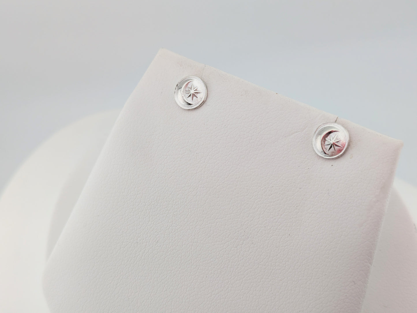 silver moon and star earrings on white background