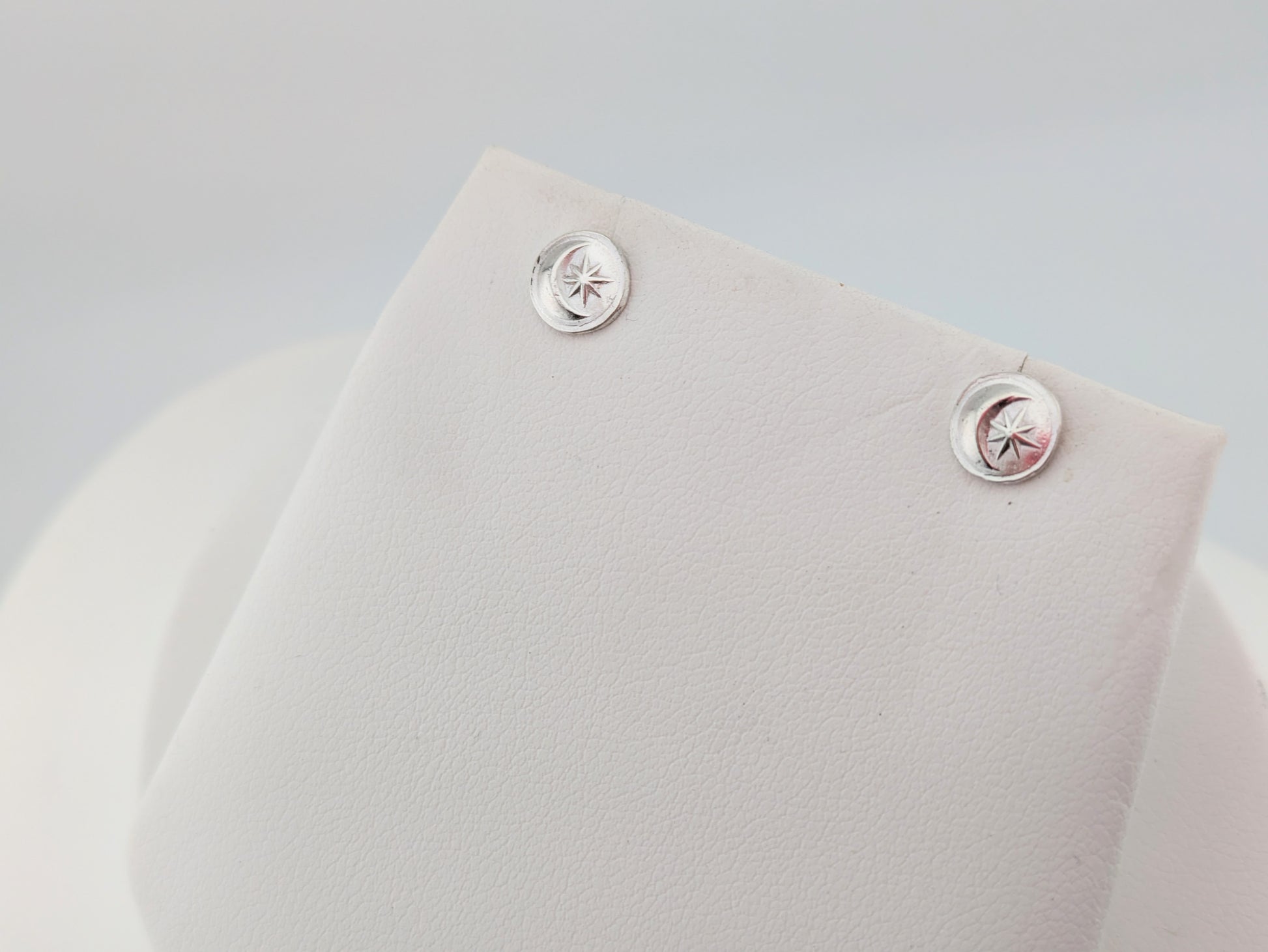 silver moon and star earrings on white background