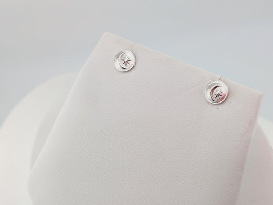 silver moon and star earrings on white background
